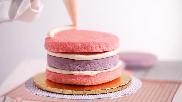 Time lapse. Baker assembling pink and purple cake layer to make unicorn cake for little girl's birth alt