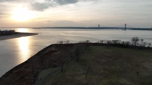 An aerial view of Calvert Vaux Park in Brooklyn, NY during a cloudy sunset. The drone camera dolly i alt