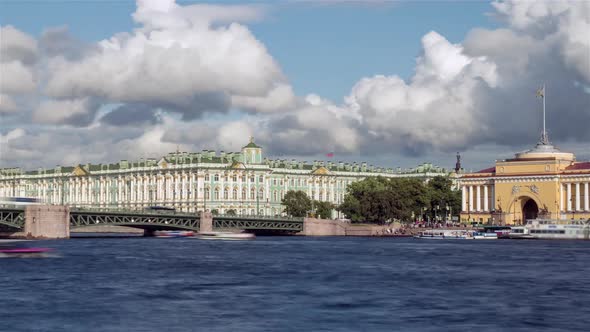 Cloudy sky over the Bridge and Winter Palace with boats on the Neva River. Saint Petersburg, Russia.