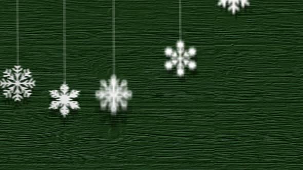 White snowflakes falling down and creating a pattern on the green background.