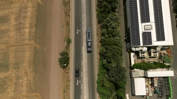 Tow truck carrying a single car on a rural highway, Aerial follow footage. alt