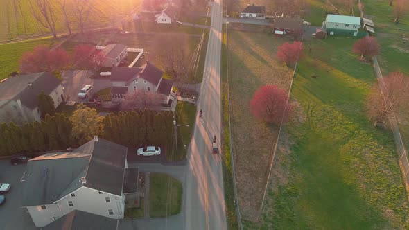 Aerial view of following a horse and buggy in late afternoon alt