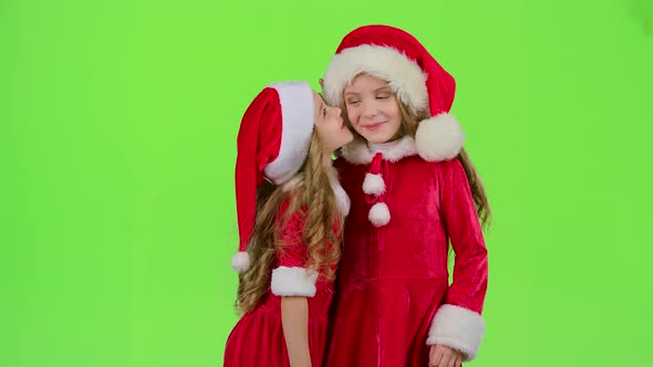 Two Baby Girls in New Year Costumes Tell Each Other Secrets, Green Screen, Slow Motion alt