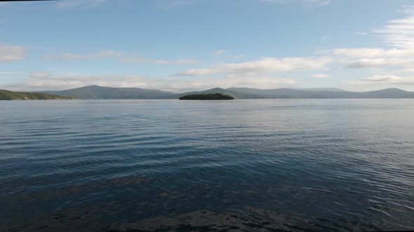 View from a boat on the Malborough Sound. Driving towards a lone island. Near Picton, New Zealand. W alt