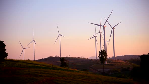 wind turbines park for make the electric power from wind in sunset time alt