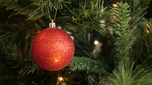 Decorative  bauble on the branch close-up 4K 2160p 30fps UltraHD footage - Red glittering  ornament  alt