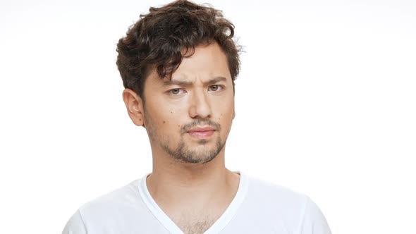 Displeased Young Handsome Man Shaking Head Looking at Camera Over White Background alt
