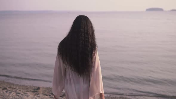 Beautiful Girl Goes Towards the Sea on the Sand and Smiles alt