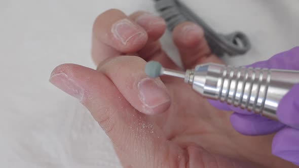 Young Woman Removes Gel Shellac Polish From Nails Using Manicure Machine, Close Up Shot