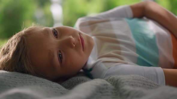 Portrait of Tranquil Boy Lying on Blanket Closeup alt