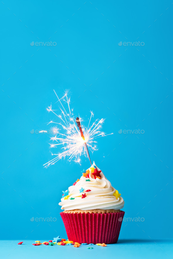 Cupcake with sparkler on blue