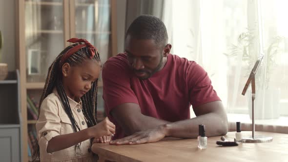 Girl Using Nail Polish on Father alt