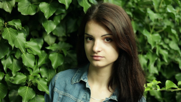 Young Woman In The Background Of Green Leaves alt