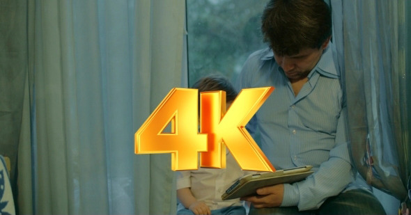 Father And Son Watching Cartoons In Tablet alt