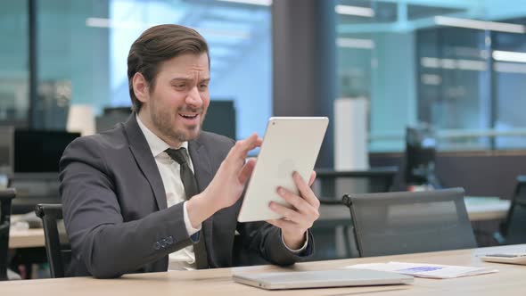 Businessman Reacting to Loss on Tablet in Office alt