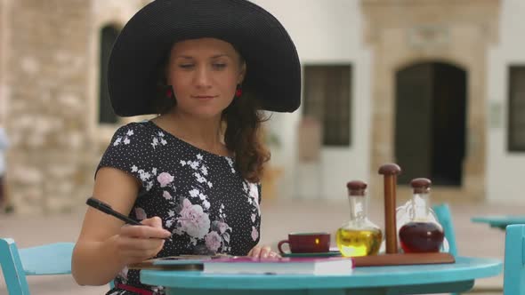 Happy Young Woman Making Notes, Drinking Coffee in Street Cafe on Vacation alt