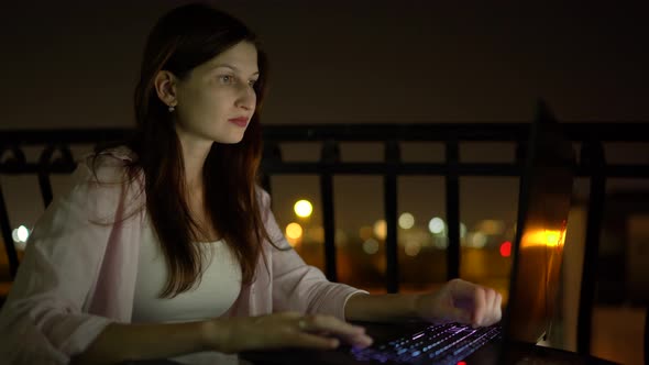 Young Woman Works with a Laptop Night Time