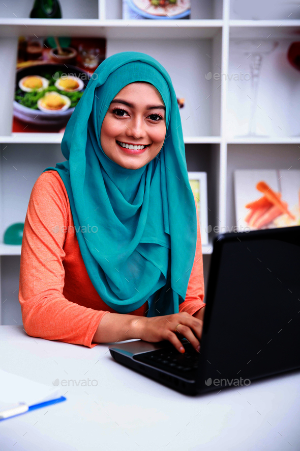 beautiful young muslim woman working on her laptop