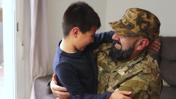 Veteran soldier greeting and hugging his son reunited after US army service - Family concept alt
