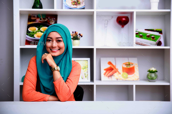 beautiful woman wearing hijab at living room with decorated back