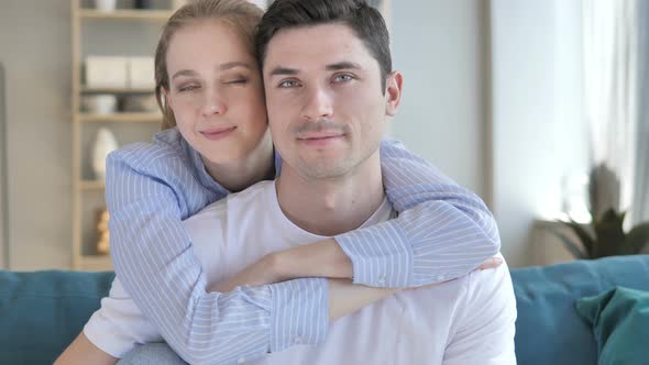 Young Couple in Hug Looking at Camera alt