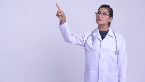 Young Happy Persian Woman Doctor Thinking and Pointing Up alt