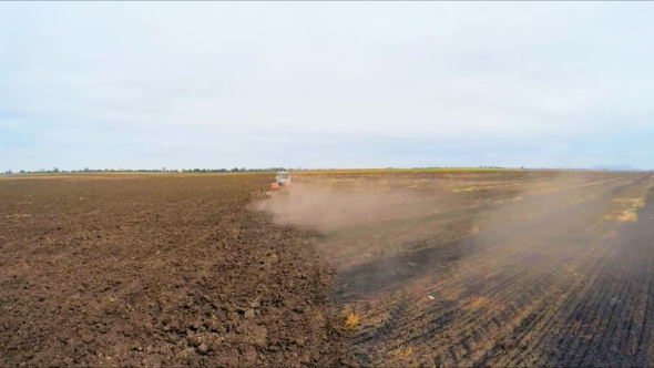 Rural Tractor Ploughing Agricultural Field In