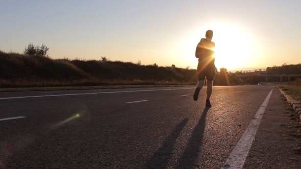 Young Man Running Outdoors In The Evening