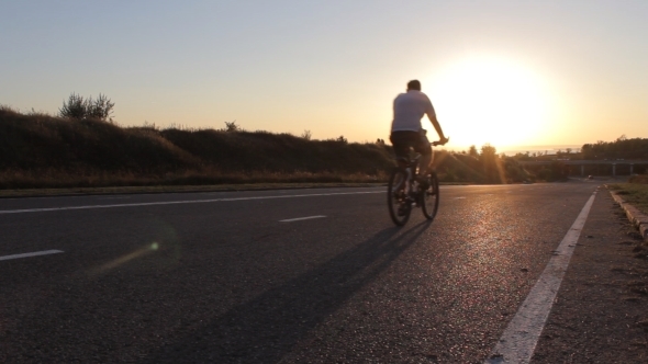 Cyclist Man On Bike In Sunny Day On Road