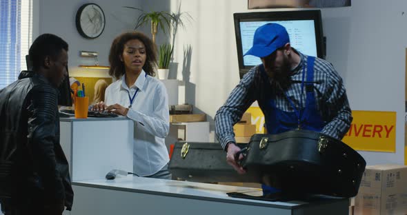 Man Sending a Guitar Case in a Delivery Center alt