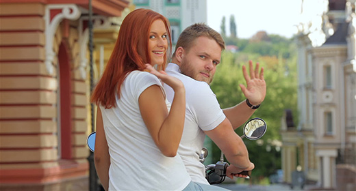 Happy freedom couple driving scooter