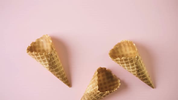 Empty waffle ice cream cones on a pink background. alt