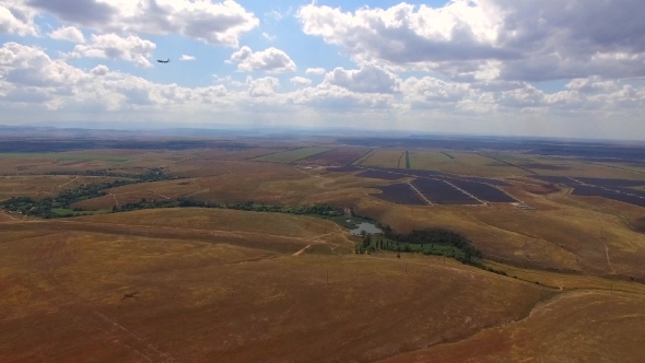 Passenger Plane Flying Over Rural Fields