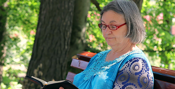 Elderly Woman Reading Bible Outdoors  alt