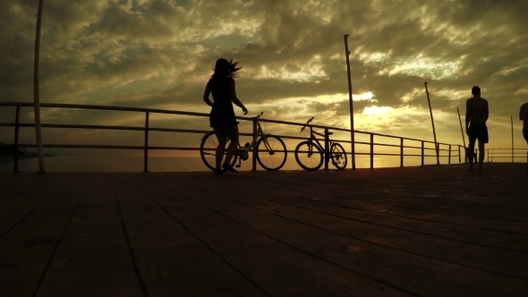 Girl On Bicycles At Sunset Sea