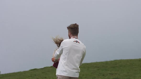 Two Young Men in National Clothes Are Having Fun Jumping and Spinning. The Fog Is Burning. alt