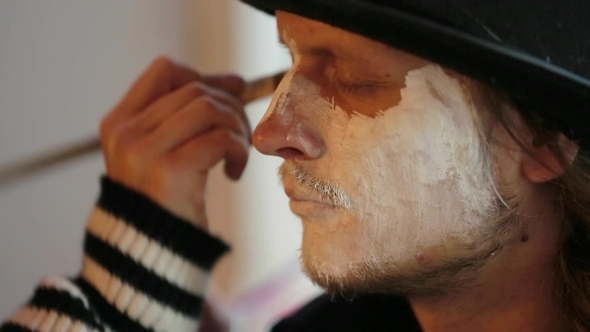 Artist Applying Makeup Onto Man's Face At