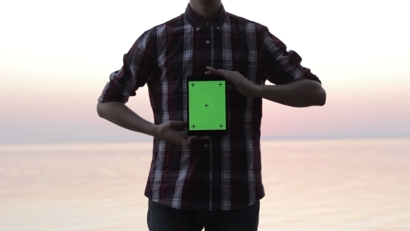 Man Holding a Tablet With a Green Screen