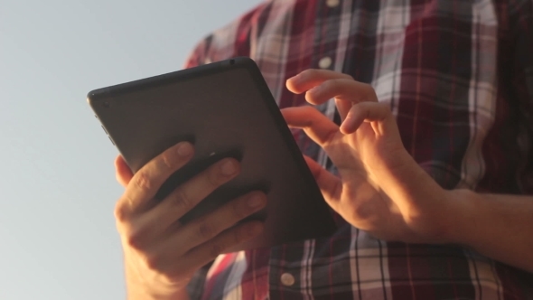 Sunny Tablet In The Hands Of The Guy On The Nature