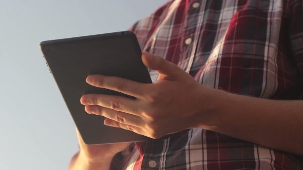 Sunny Tablet In The Hands Of The Guy On The Nature