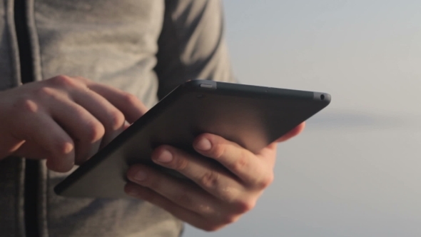 Sunny Tablet In The Hands Of The Guy On The Nature