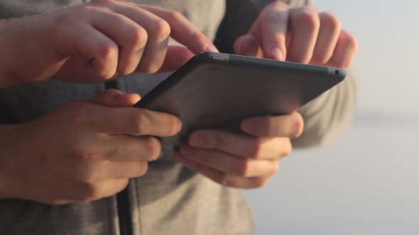 Young Mans Hands Touch a Tablet.