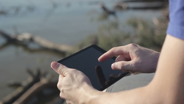 Young Man Working Outdoors With Tablet.