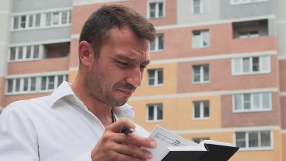 Distressed Businessman in a White Shirt Looking Through Records Embezzlement alt