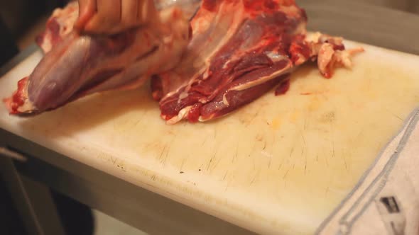 Chef Cutting Meat In Kitchen alt