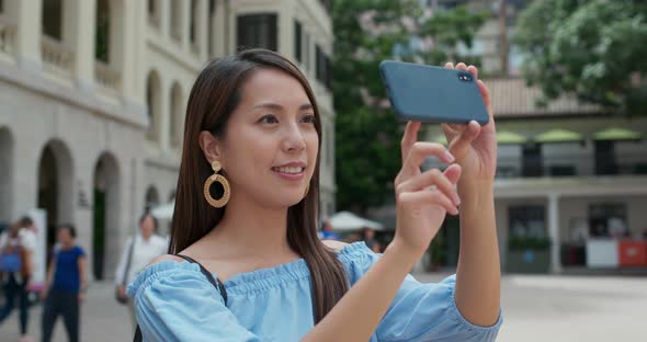 Woman tourist take photo on cellphone and visit old landmark in Hong Kong alt