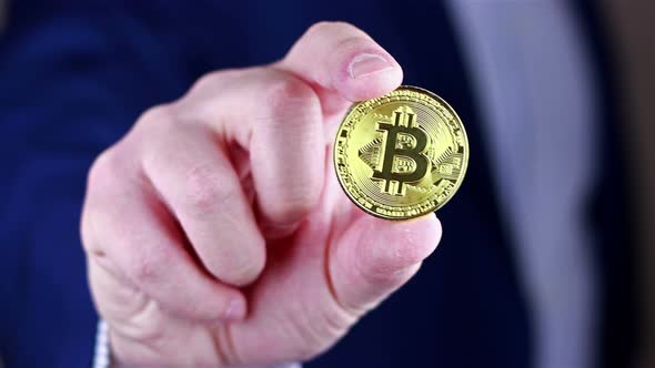 Businessman holds Bitcoin in his hand.