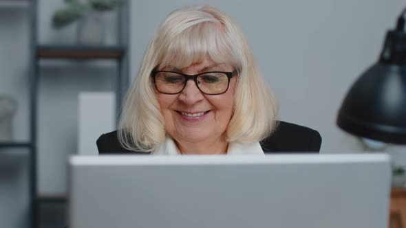 Senior Businesswoman Wears Glasses Working at Home Office Online Webinar Using Laptop Computer alt