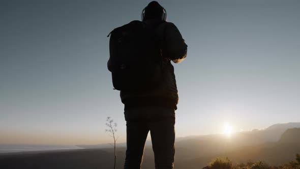 Silhouette of a Young Explorer in the Mountains at Sunset alt