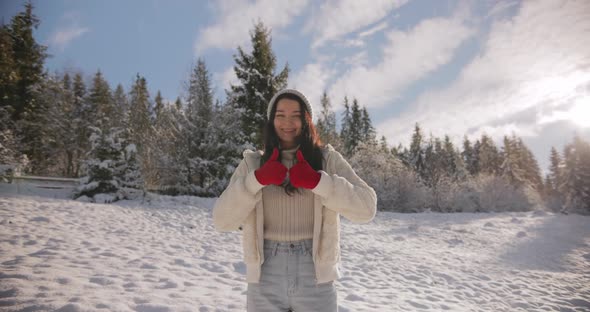 Woman in Winter Clothes Thumbs Up in Front of Mountain Forest Outdoors alt